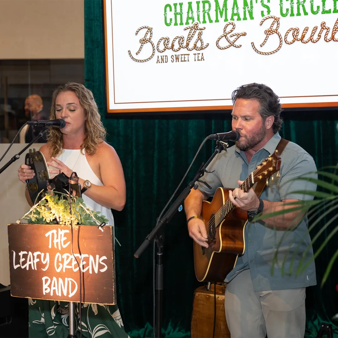 Two performers singing on stage at a concert.