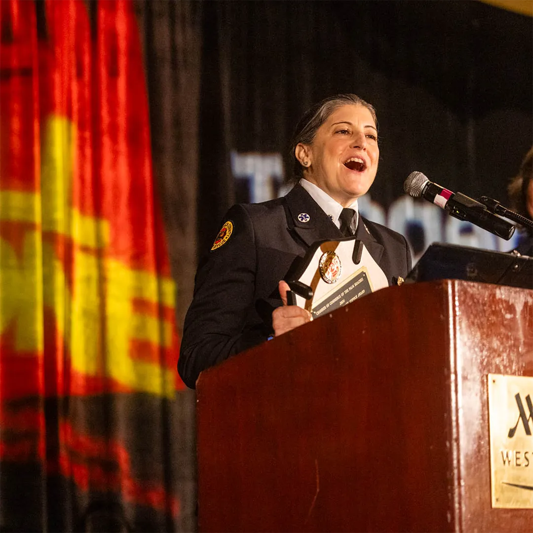 Woman in uniform delivers a speech at a podium.
