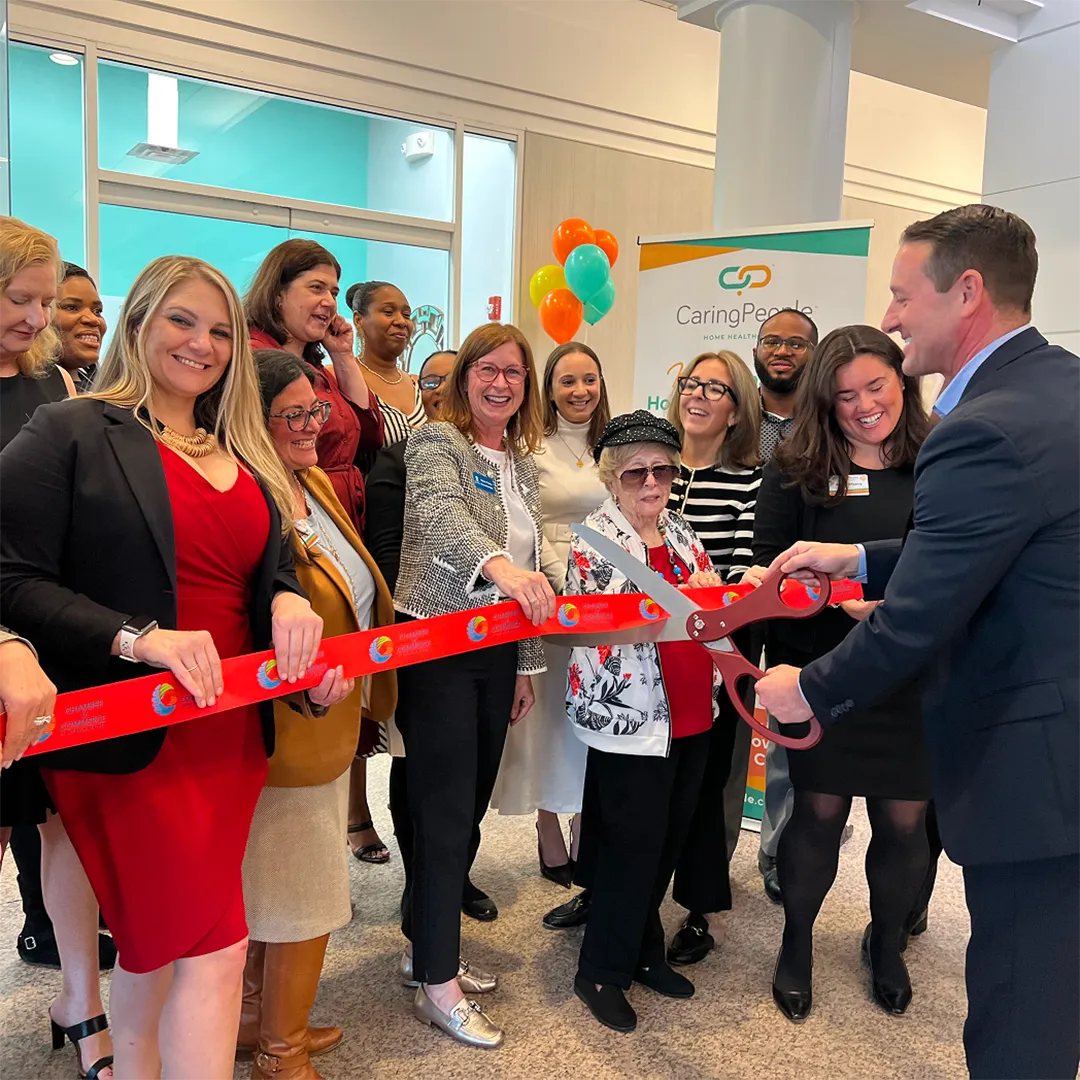 Group of people cutting a ceremonial ribbon at an event.