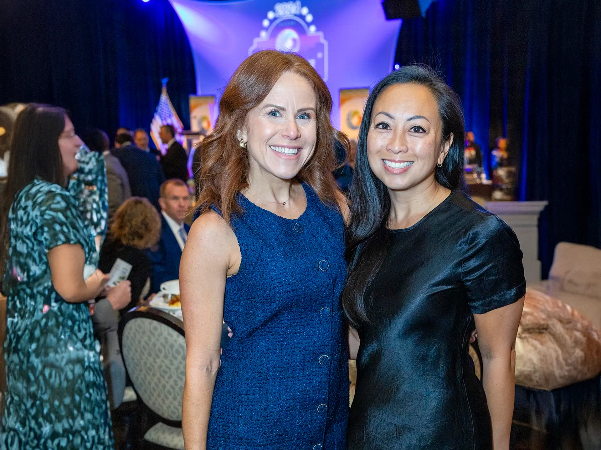 Two ladies smiling at the Chamber breakfast