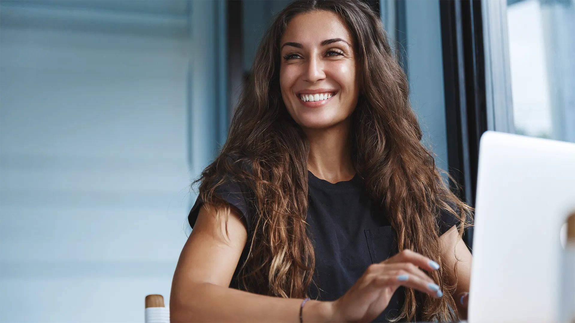 Woman smiles while working on her laptop.